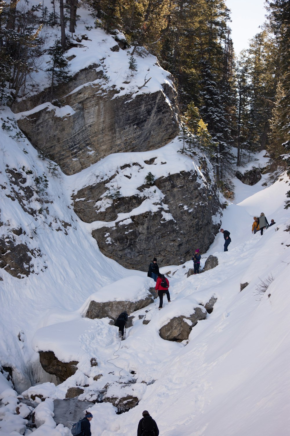 a group of people climbing up a snow covered mountain