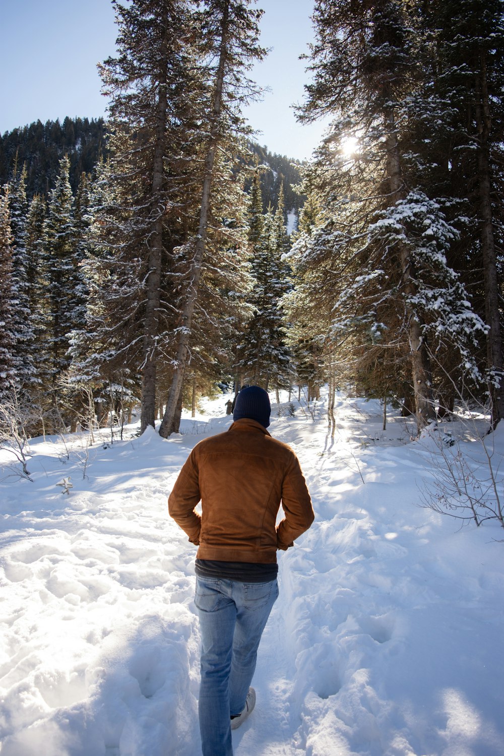 a man walking through a snow covered forest