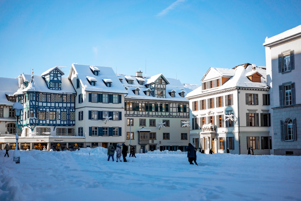 a group of people standing in the snow in front of a building