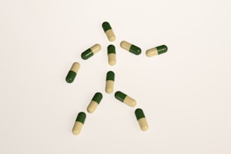 a group of green and white pills on a white surface