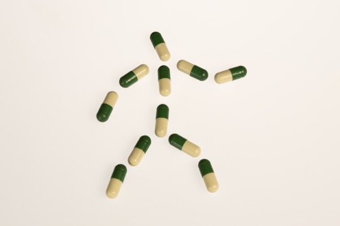 a group of green and white pills on a white surface