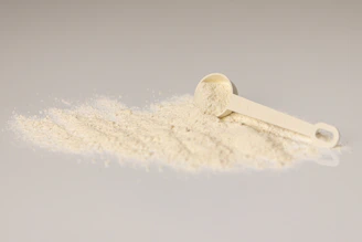 a pile of white powder next to a scoop of powder
