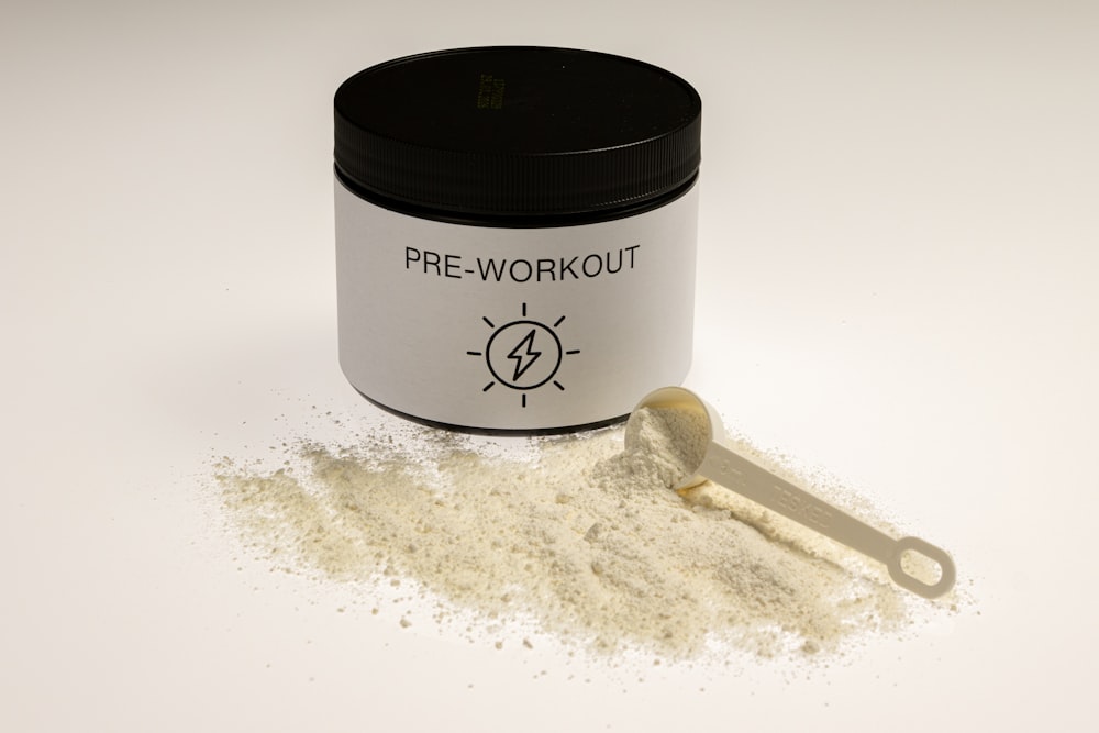 a jar of pre - workout powder next to a spoon