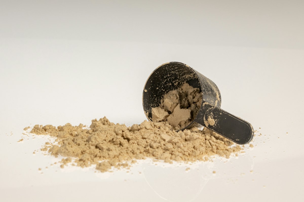 Pre-workout là gì: một muỗng bột pre-workout đặt trên mặt bàn trắng