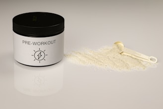a jar of pre - workout powder next to a scoop of powder