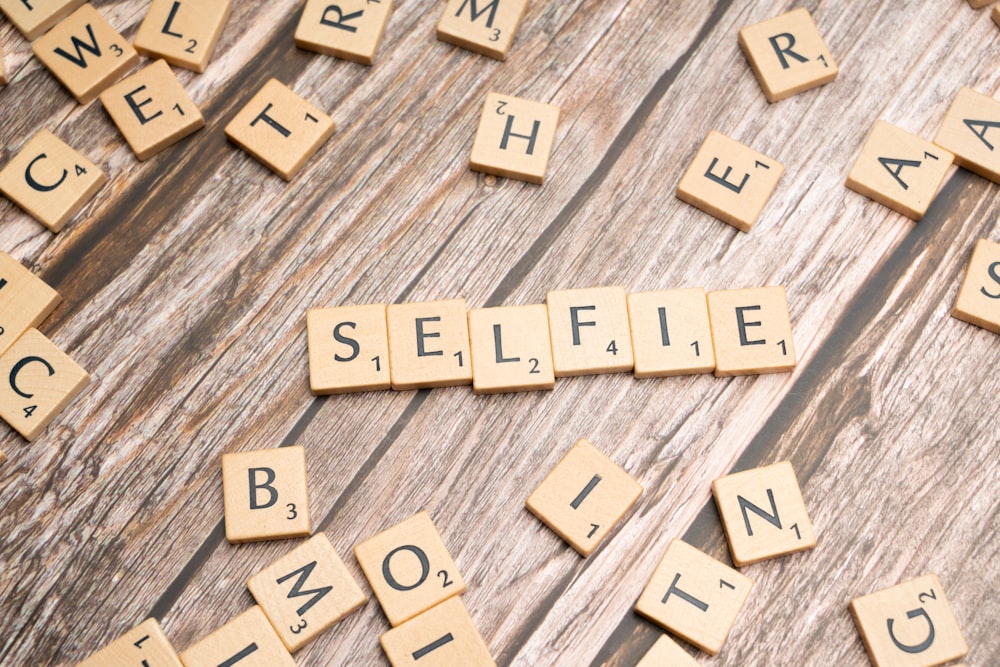 scrabble letters spelling selfie on a wooden surface
