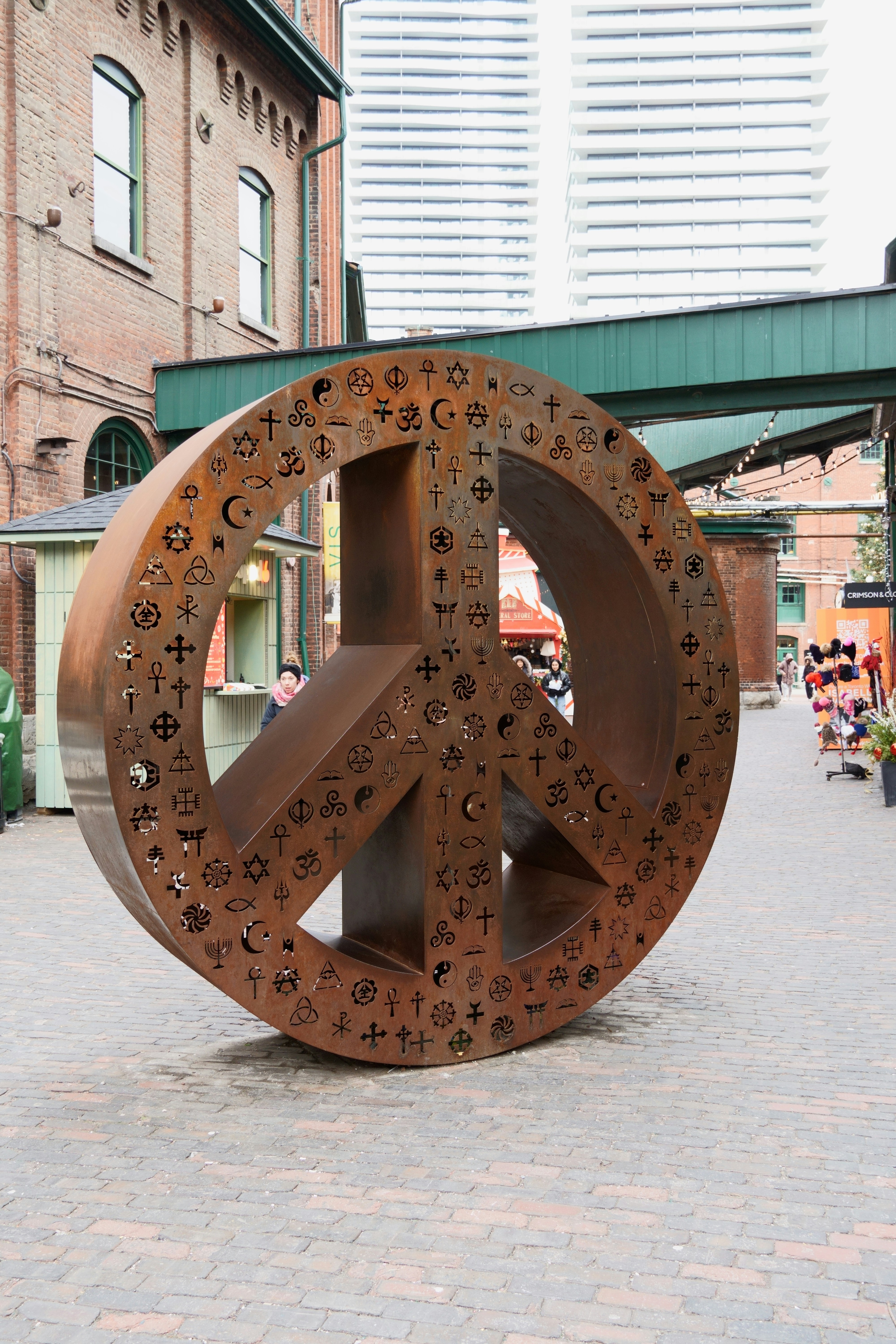 A large metal peace sign sitting on top of a sidewalk photo – Free Town ...