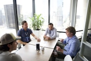 a group of men sitting around a table talking