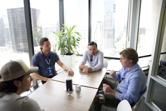 a group of men sitting around a table talking