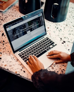 a woman sitting at a table using a laptop computer