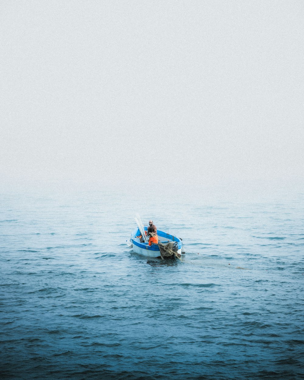 a person in a small boat in the middle of the ocean