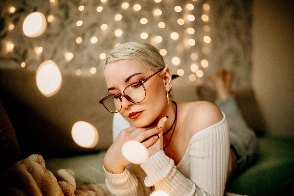 Eine Frau mit Brille liegt auf einer Couch