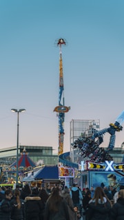 a crowd of people standing around a carnival ride