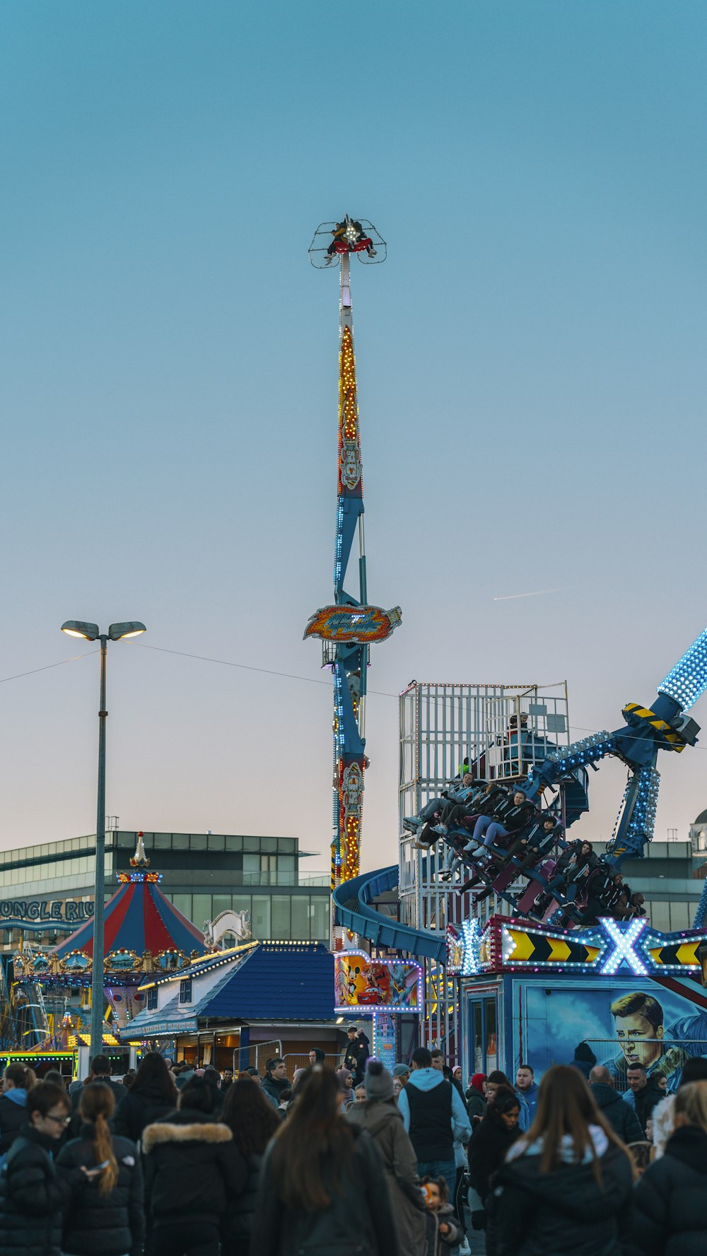 a crowd of people standing around a carnival ride