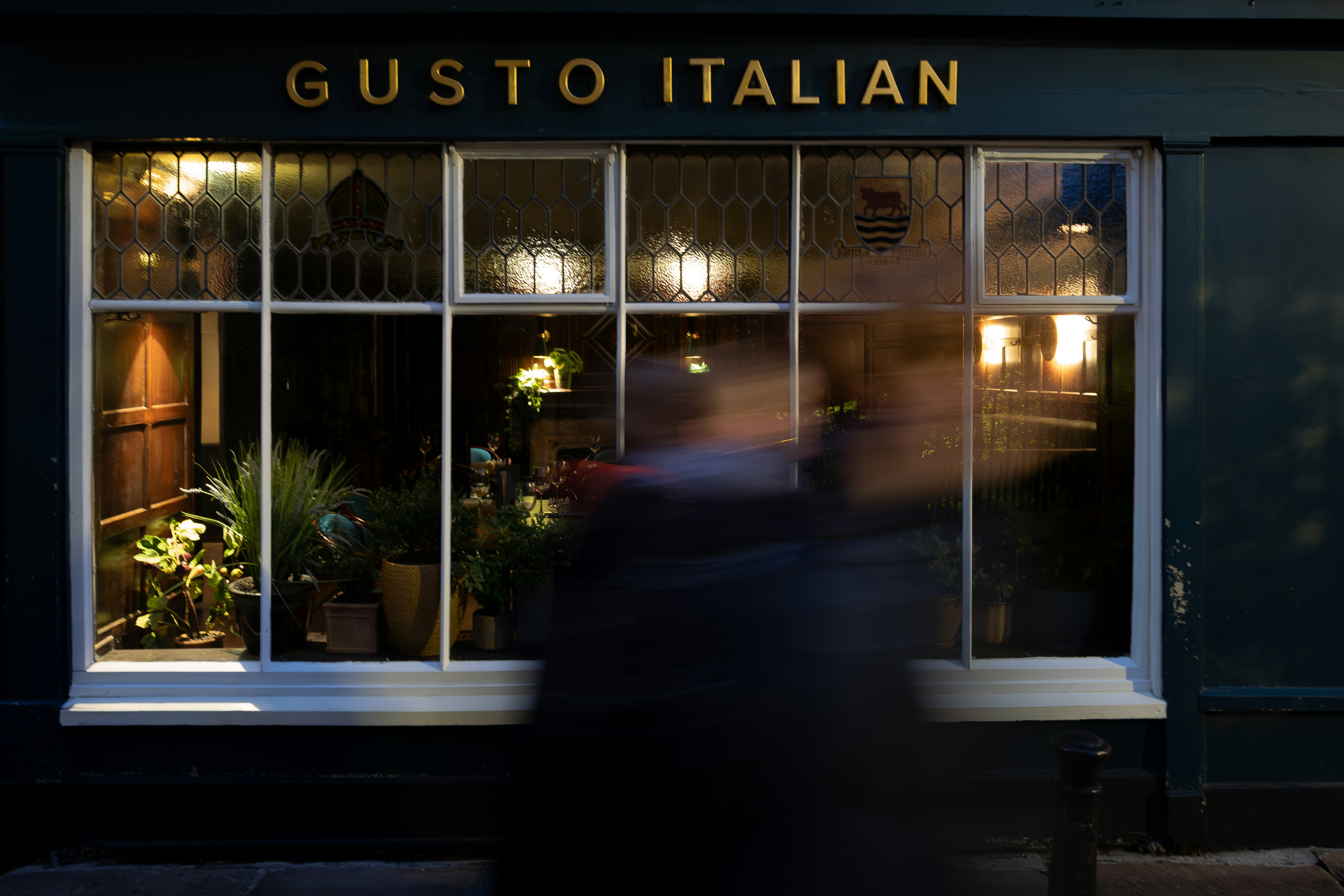 Ein verschwommenes Bild einer Person, die an einer Ladenfront vorbeigeht