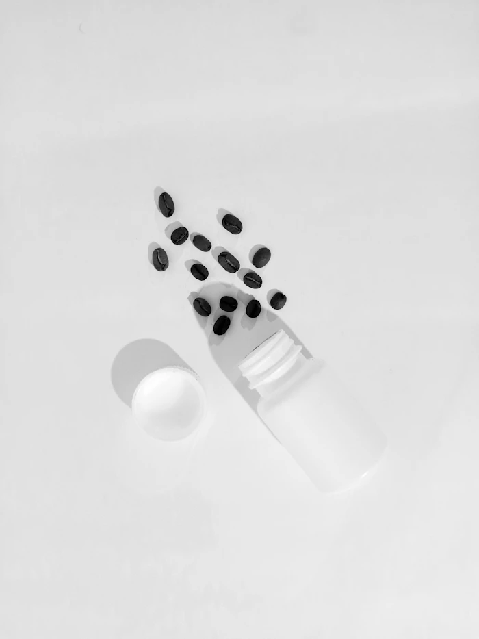 A bottle of pills beside a pill organiser
