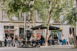 a group of people sitting at a table under an umbrella