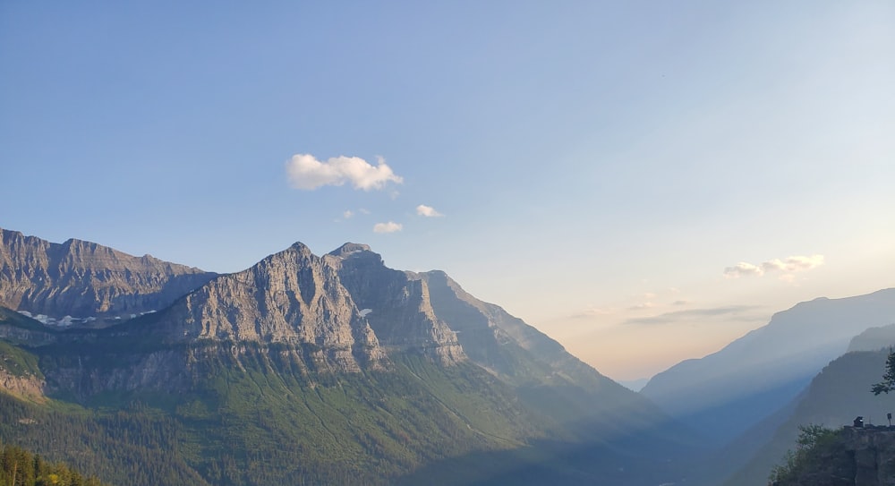 a scenic view of a mountain range with a lake in the foreground