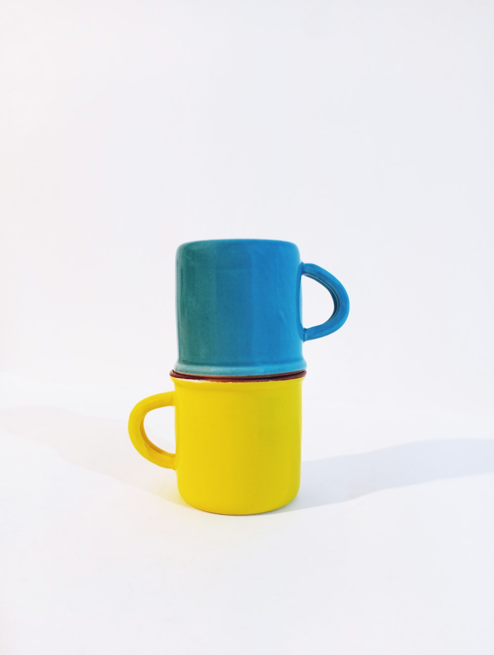 a yellow and blue cup sitting on top of each other