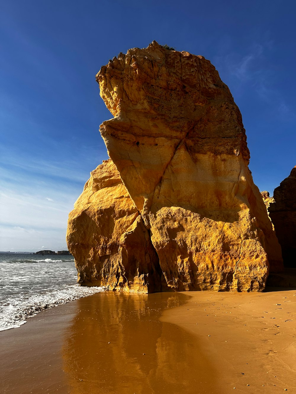 a large rock sitting on top of a sandy beach