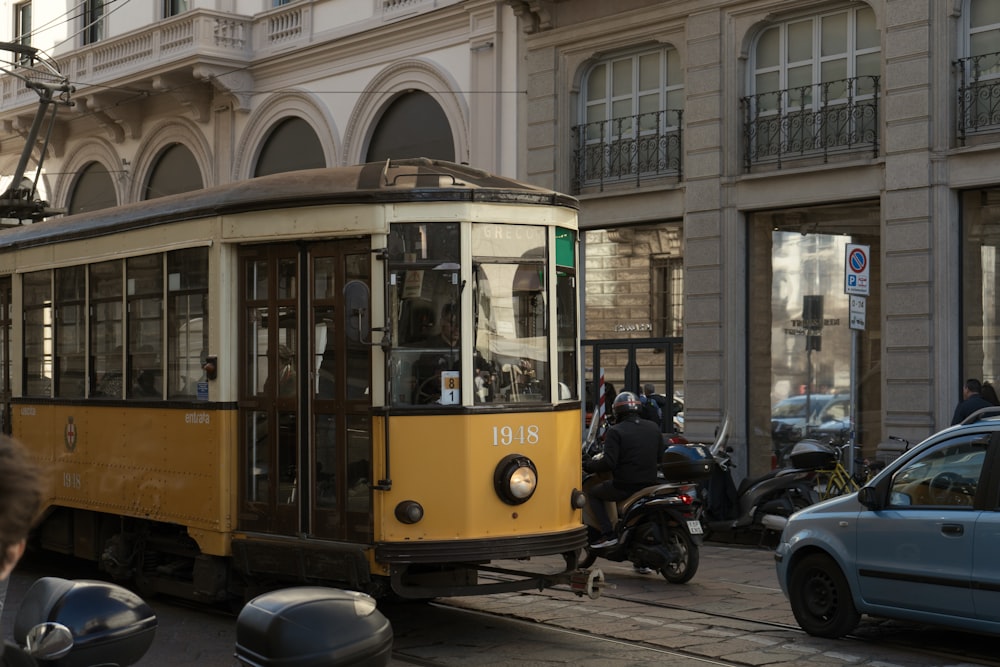 a yellow trolley car on a city street