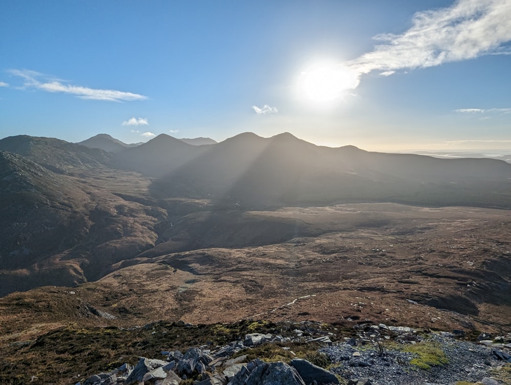 the sun is shining over a mountain range