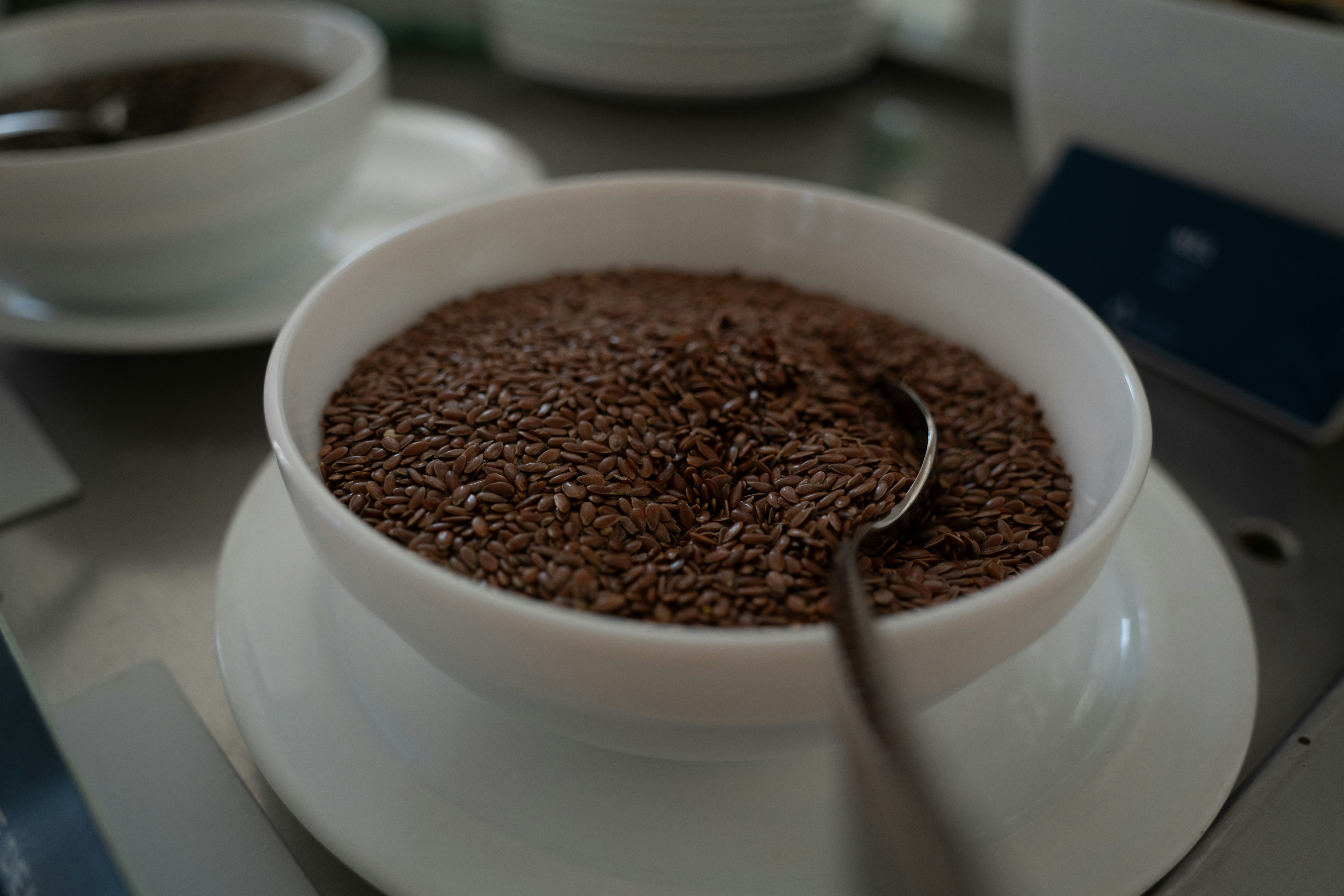 Brown flax seeds in a wooden bowl on a rustic surface, warm natural light