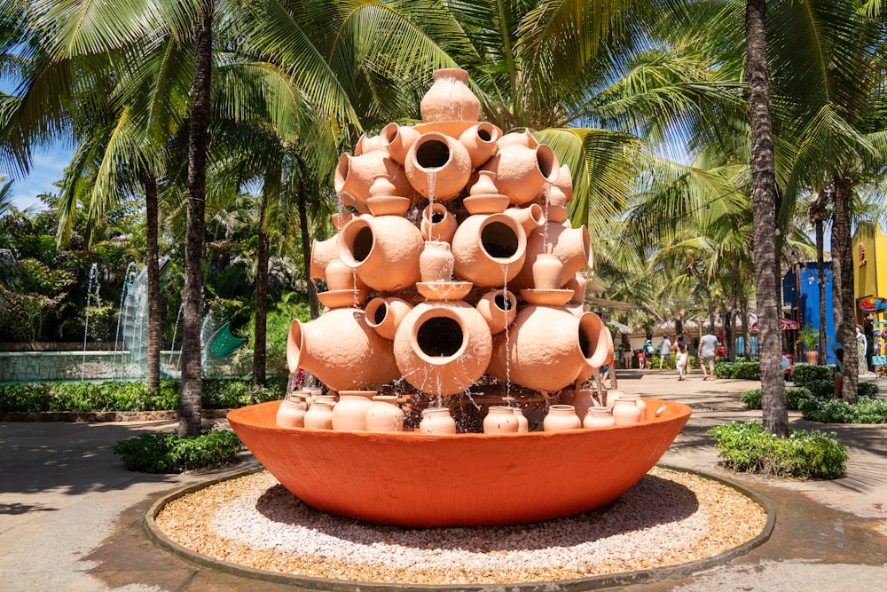 a large orange bowl filled with lots of vases