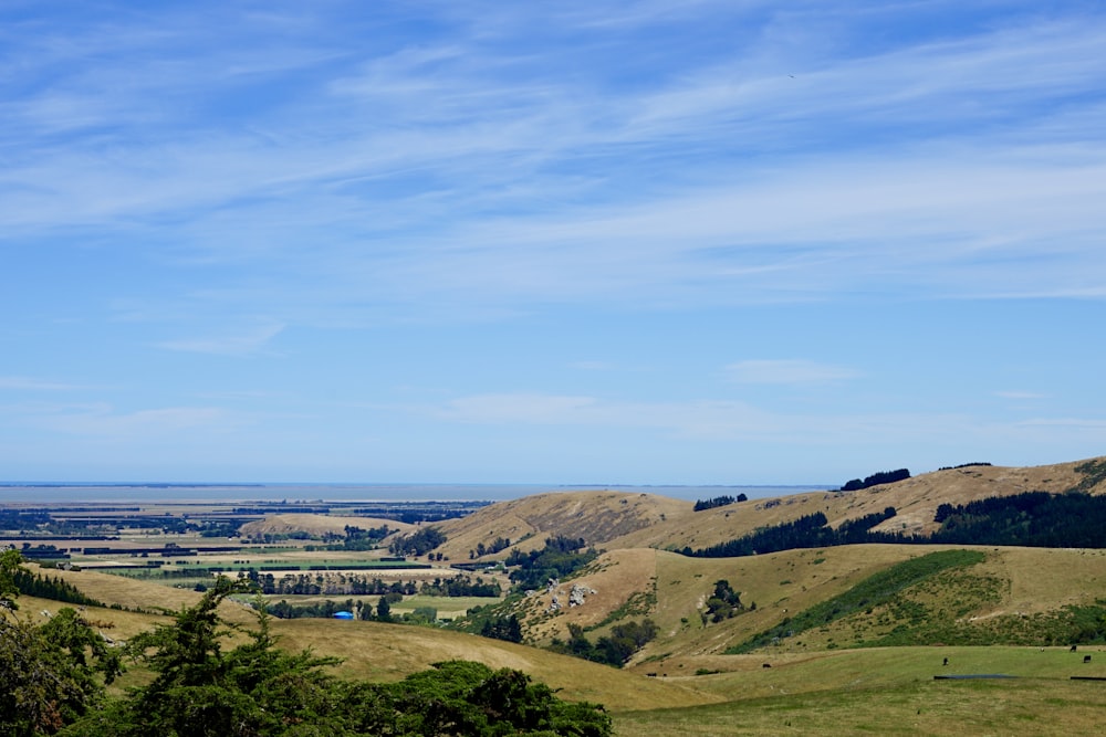 a scenic view of a valley with rolling hills in the distance