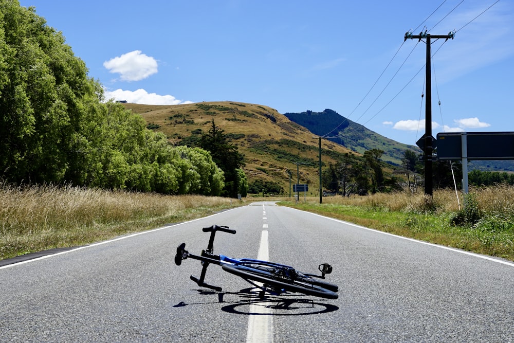 a bicycle laying on the side of a road