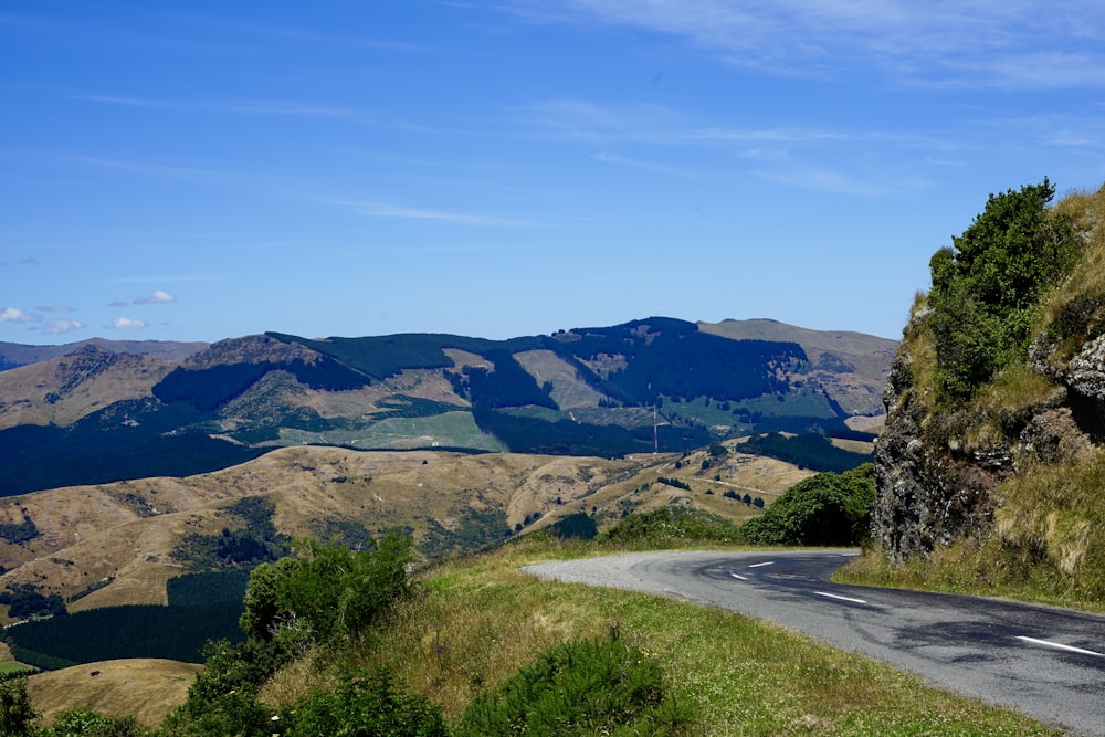 a winding road with a view of mountains in the distance