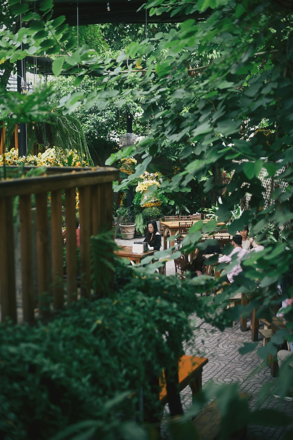 a group of people sitting at a table in a garden