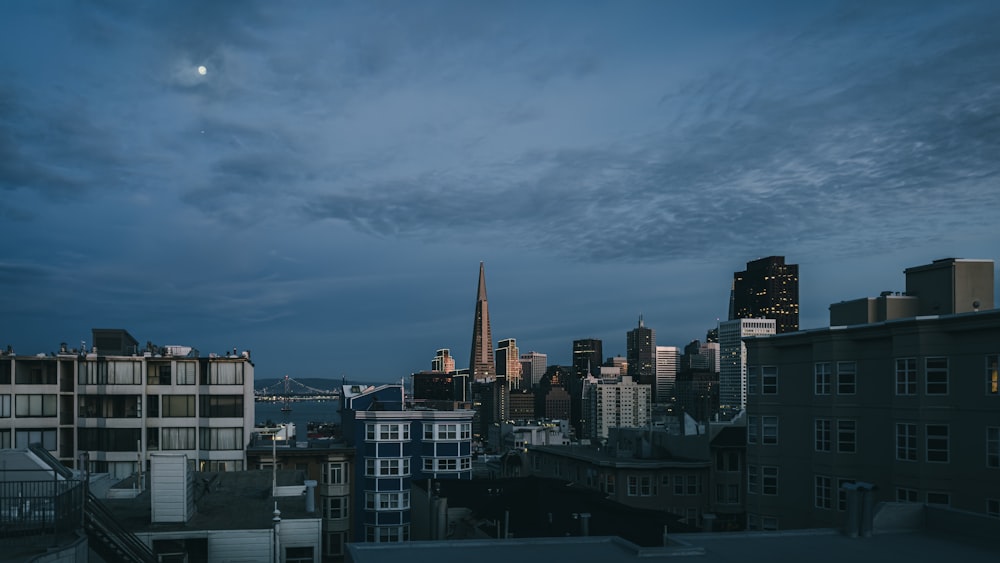 a view of a city at night with the moon in the sky