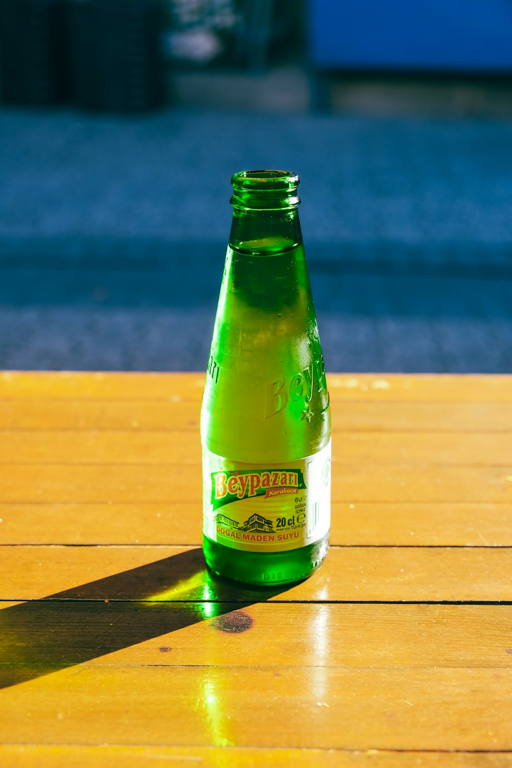 a green bottle sitting on top of a wooden table