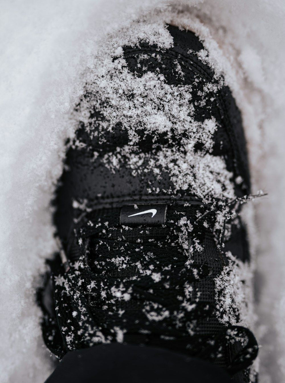 uma pessoa em pé na neve com seus sapatos cobertos de neve