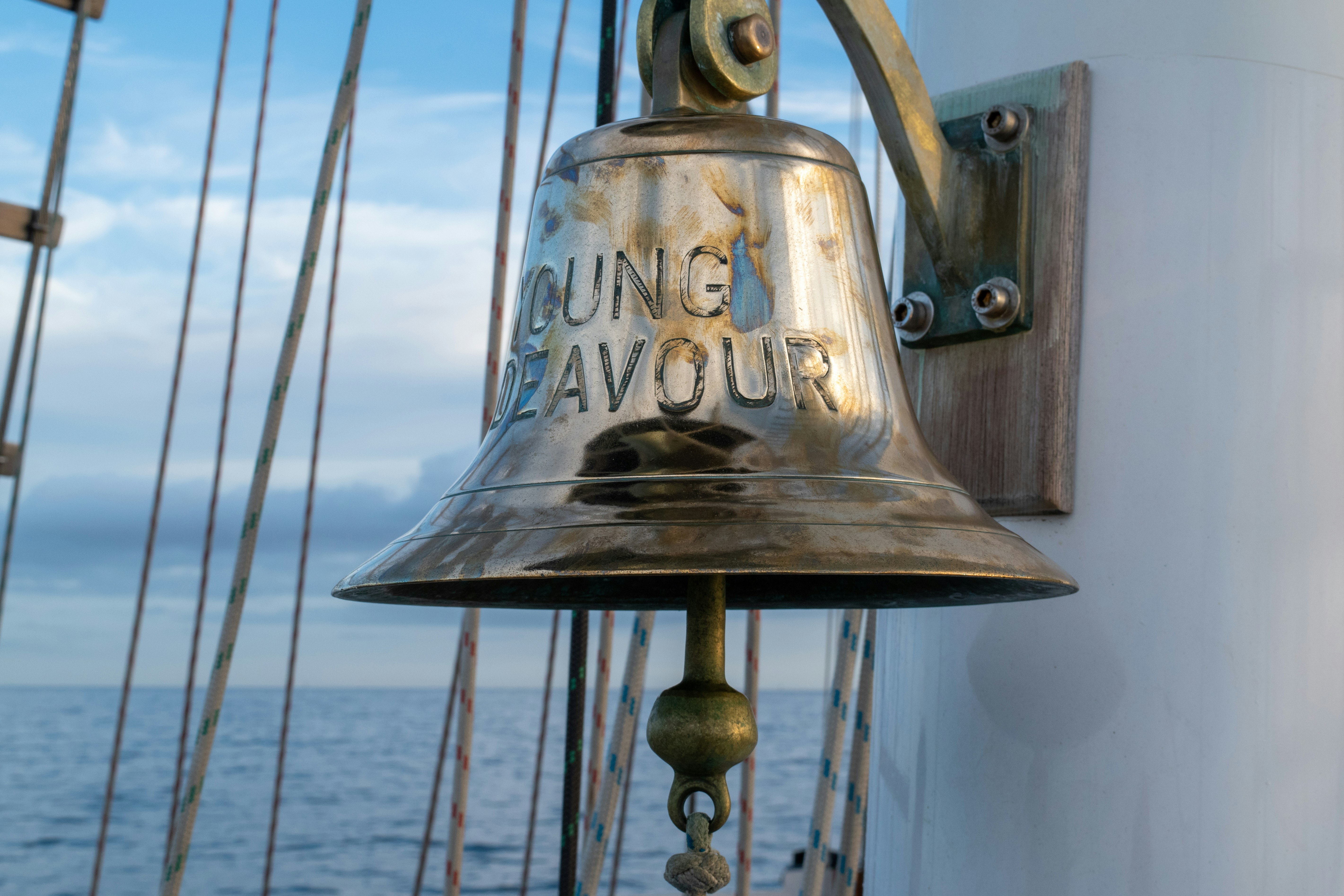 a bell on the side of a boat near the ocean