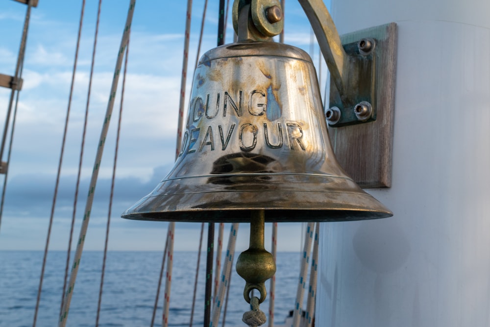 a bell on the side of a boat near the ocean