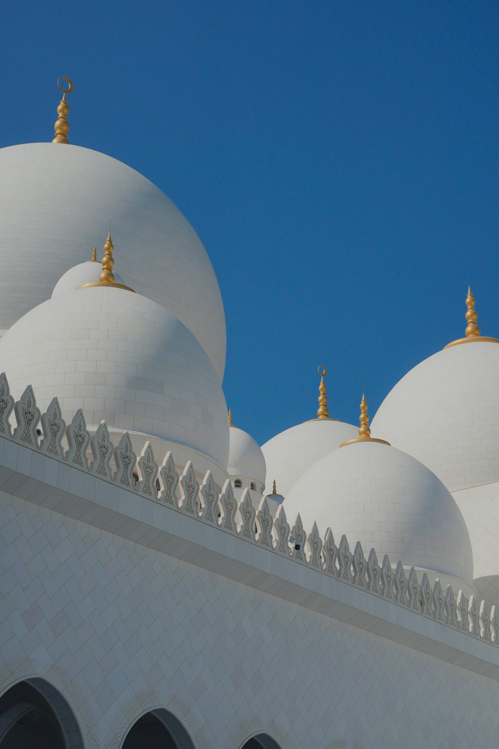 a close up of a white building with gold domes