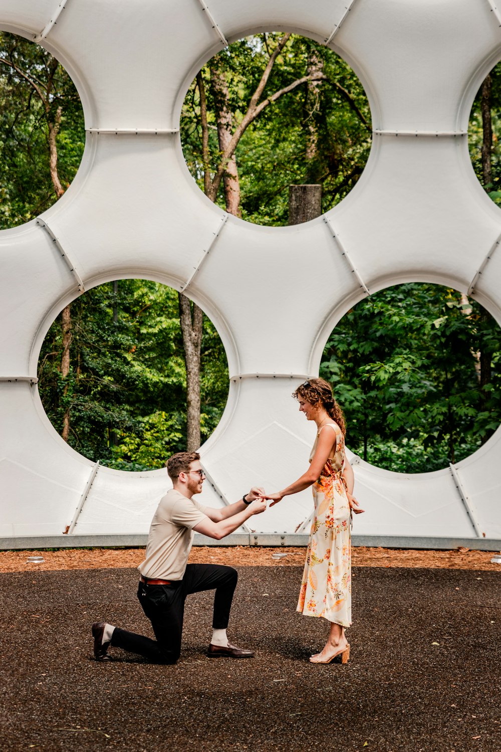 a man kneeling down next to a woman