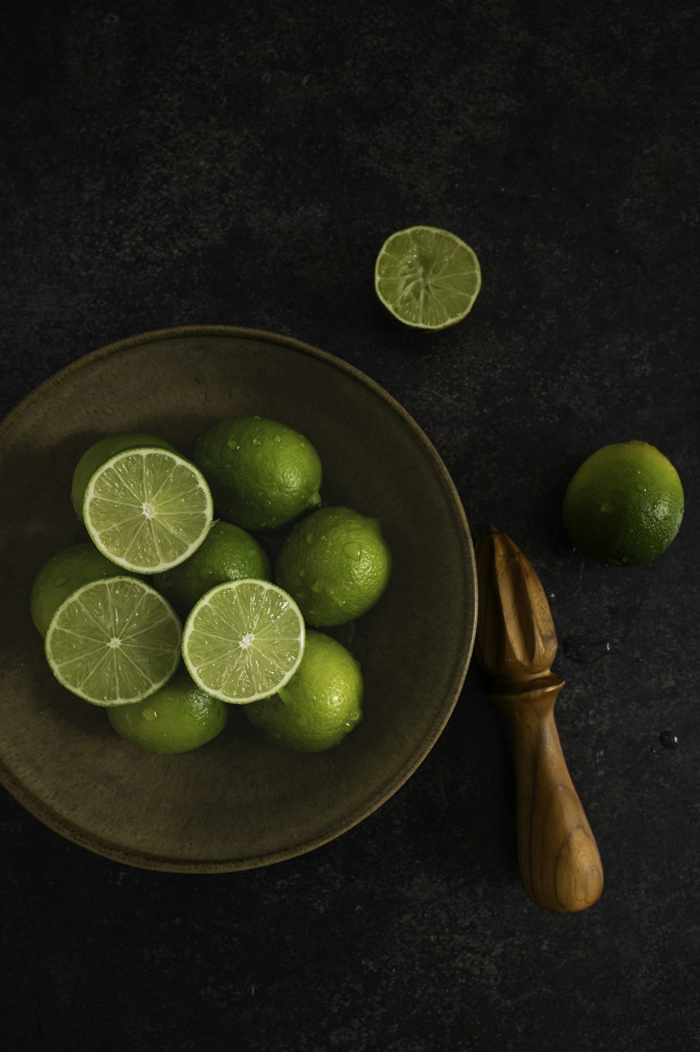 a bowl of limes and a knife on a table