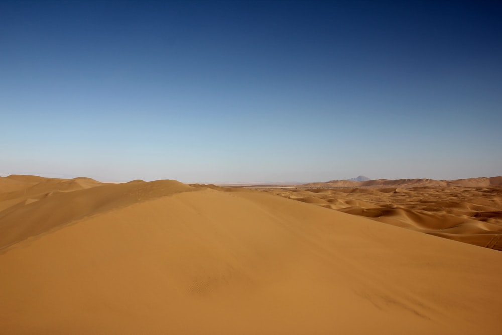 sand dunes in the desert under a blue sky