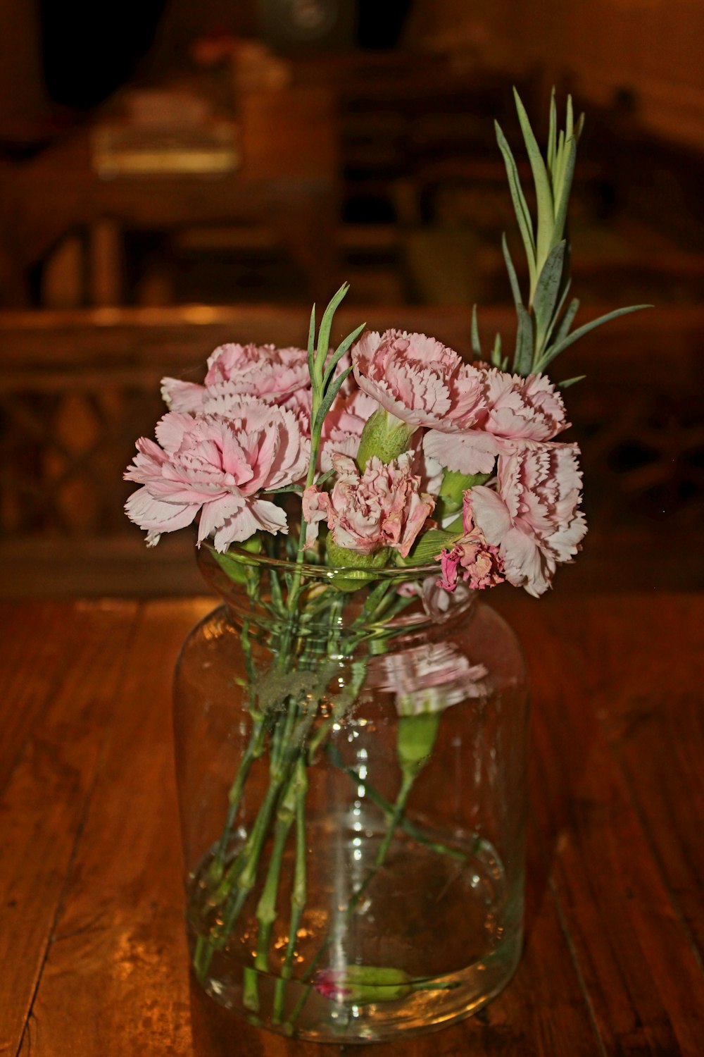 a vase filled with pink flowers on top of a wooden table