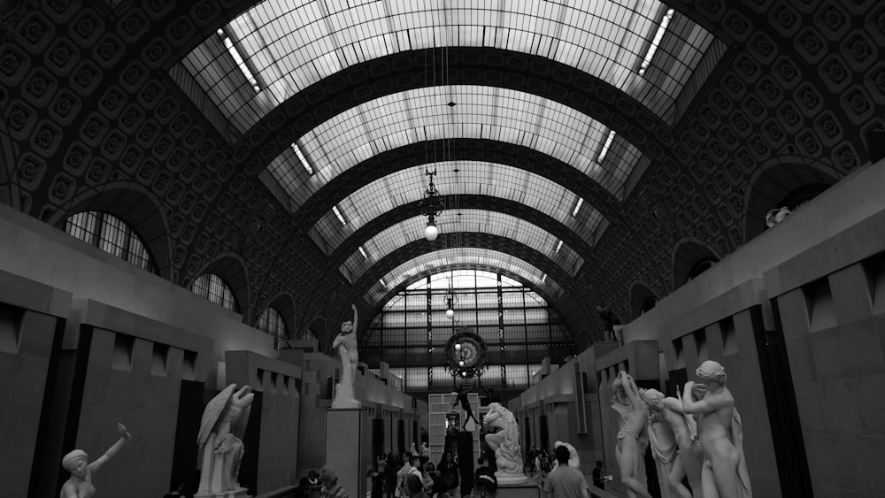 a black and white photo of statues in a building