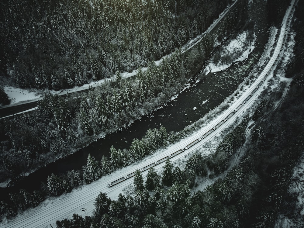 an aerial view of a snow covered road and trees