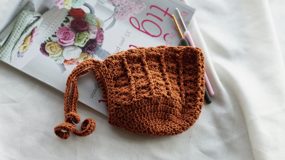 a crocheted purse sitting on top of a magazine