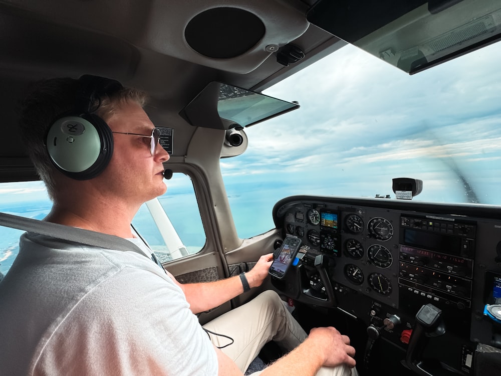 飛行機のコックピットに座り、ヘッドフォンをつけている男性