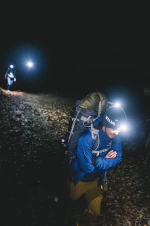 Randonneur avec lampe frontale dans la nuit