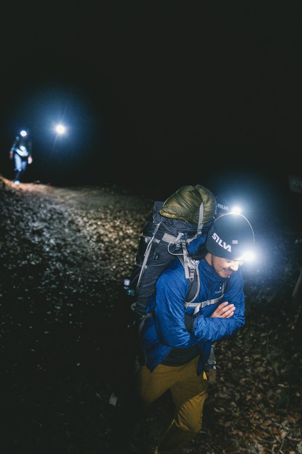 a man with a backpack and a flashlight in the dark