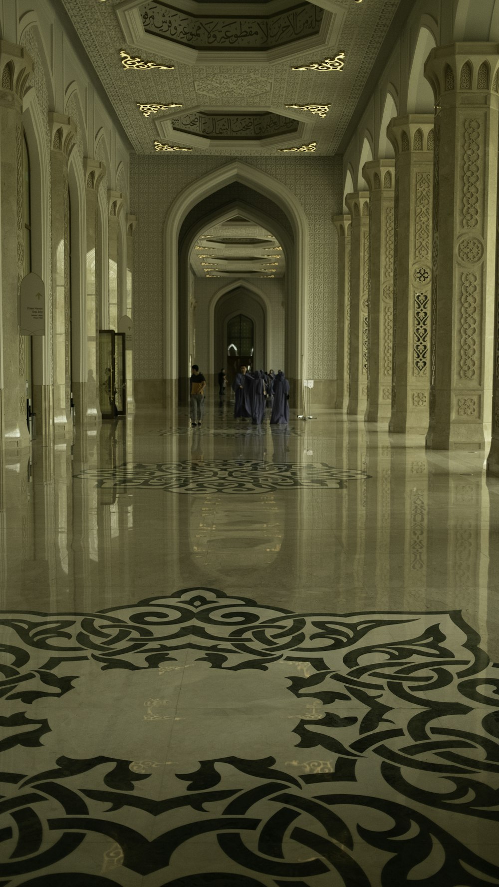 a group of people walking down a long hallway