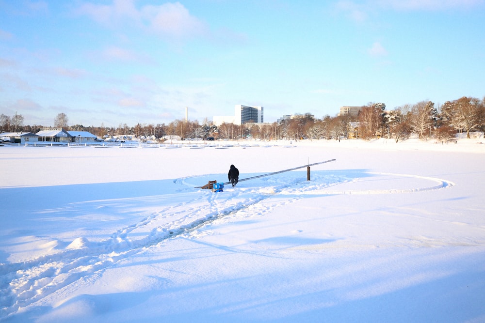 a man walking across a snow covered field